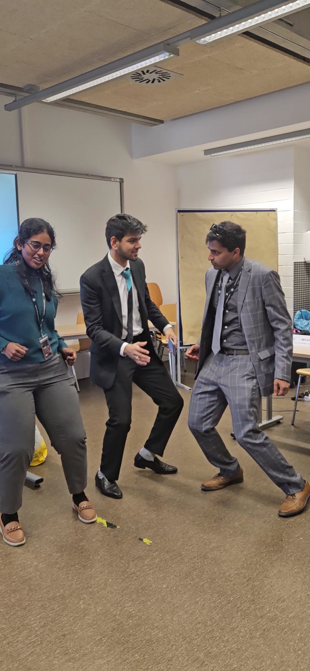Three delegates in suits dancing in a committee room